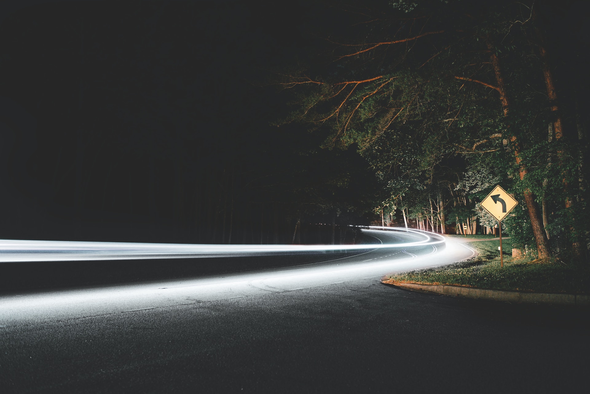 Dark road illuminated by streaks of light.  Photo by Clay Banks on Unsplash.