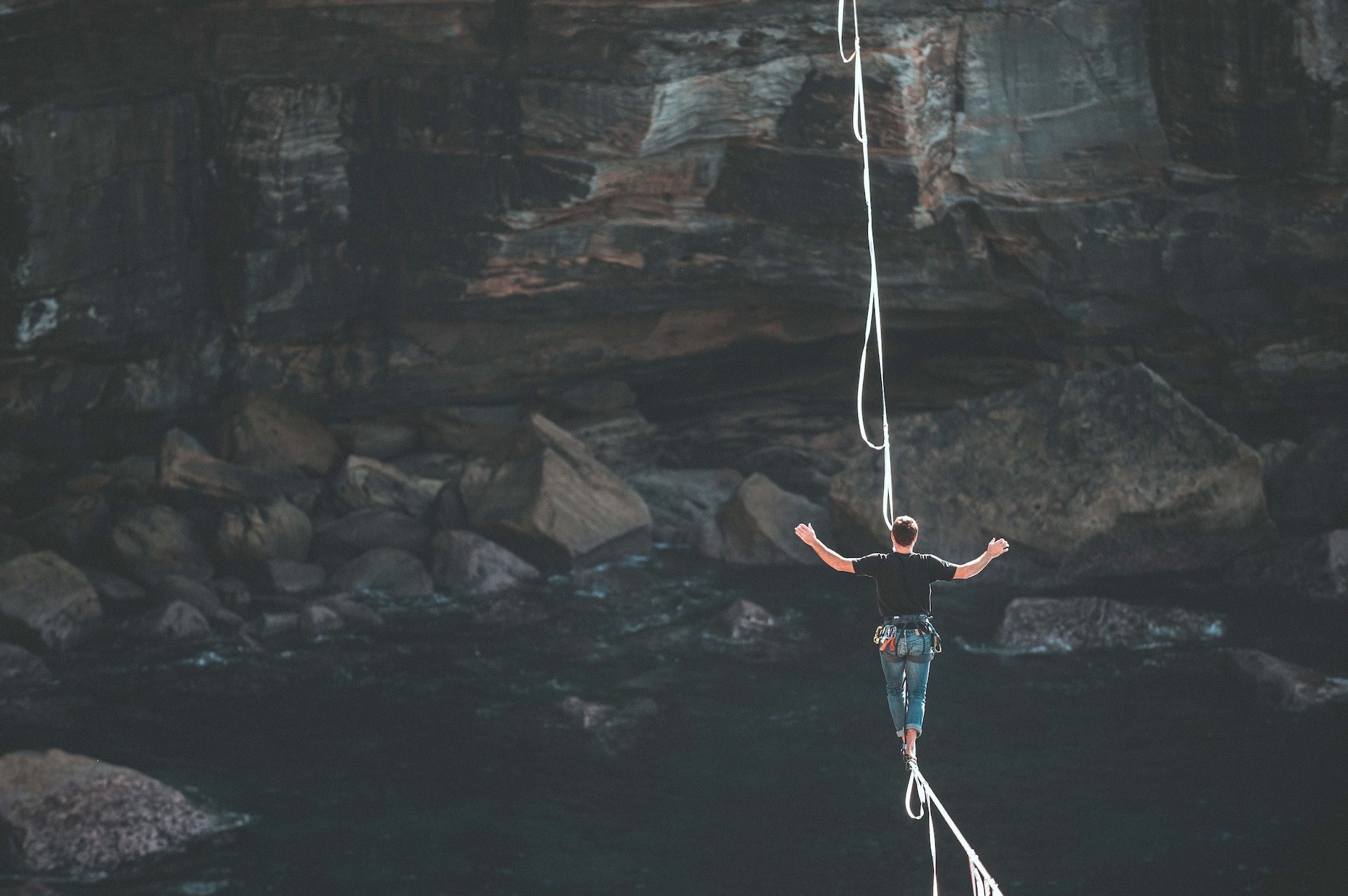 image of a person walking on a tightrope, across a canyon