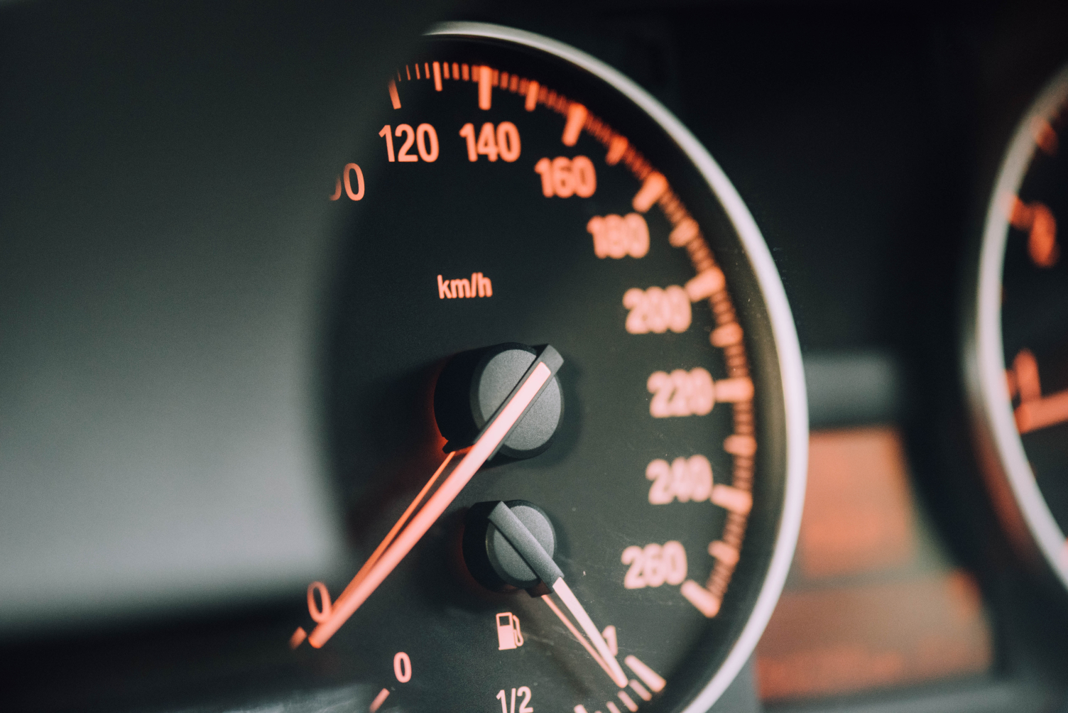 Image of a car's speedometer. There are orange numbers on a black background.