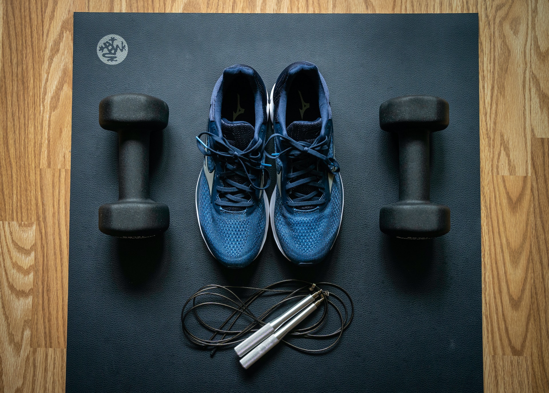 Image of athletic gear (sneakers, dumbbells, and a jump rope) on a mat.  Photo by Alexandra Tran on Unsplash.
