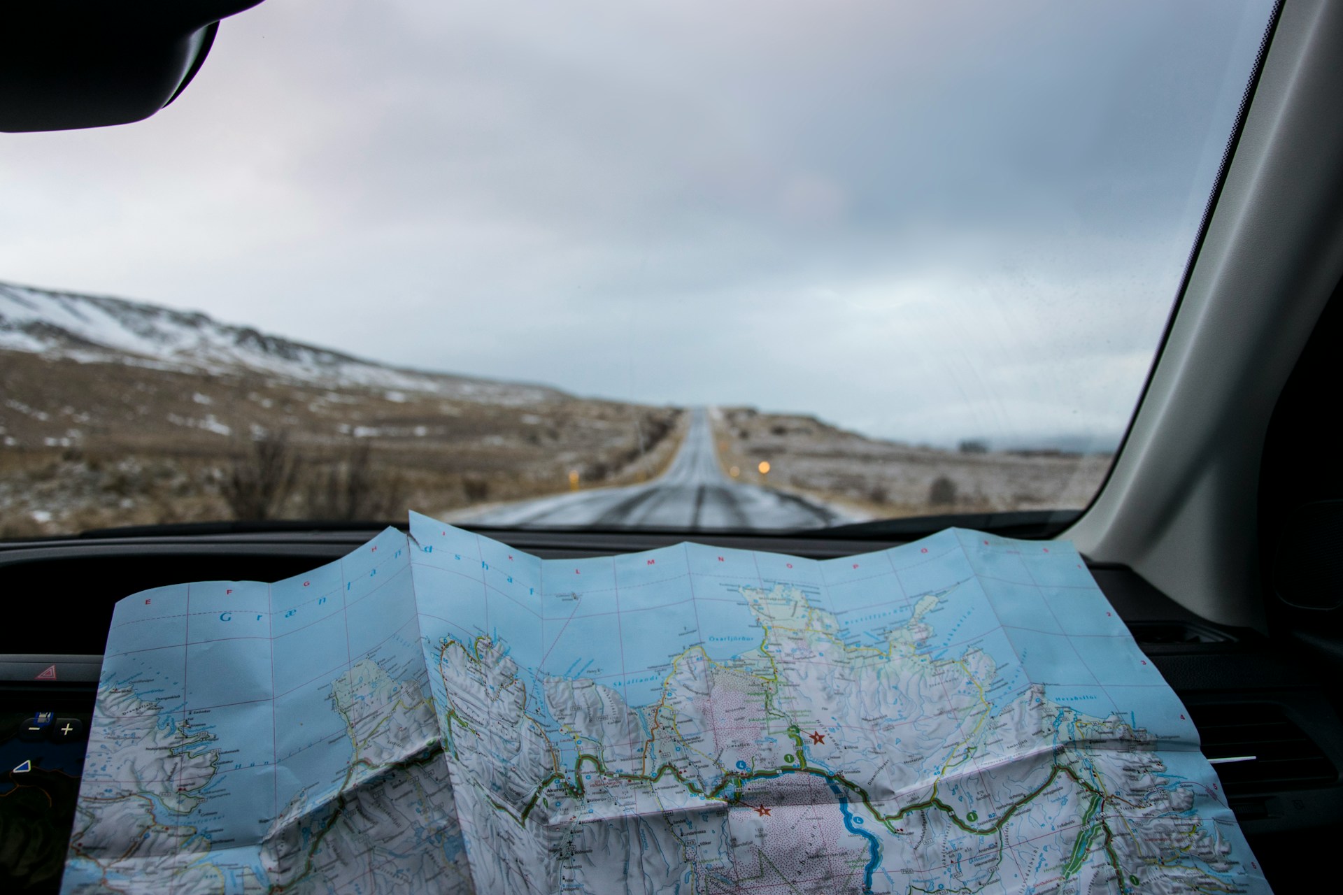 A photo of a map spread out on the dashboard of a car.  Photo by Tabea Schimpf on Unsplash.