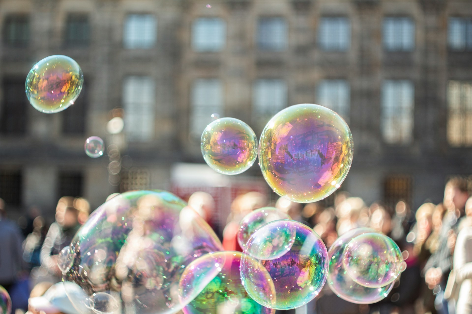 Bubbles floating in the air at city square. Photo by Pieter on Unsplash.