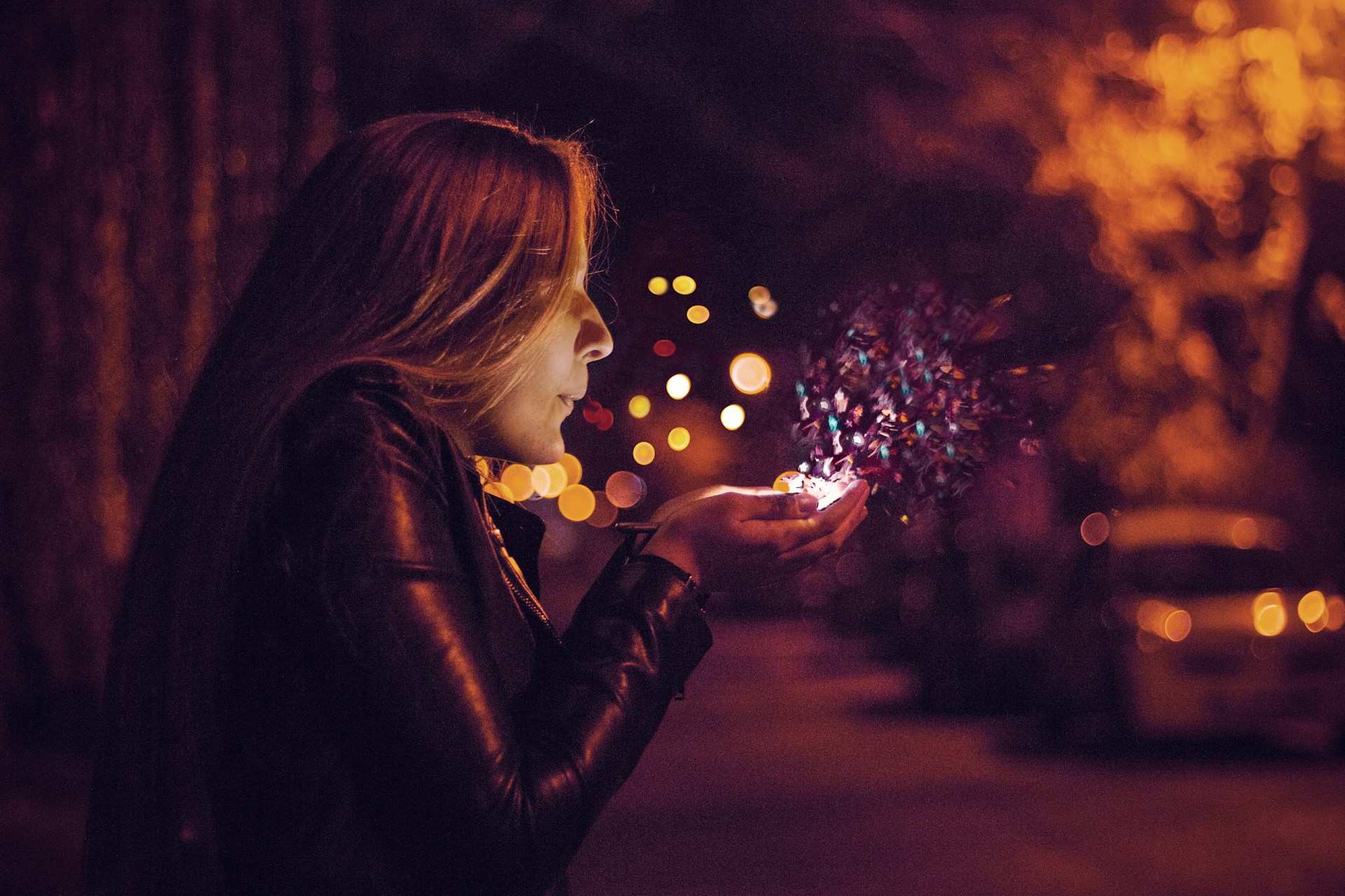 A woman blowing glitter sprinkles out of her hand. Photo by Almos Bechtold on Unsplash.