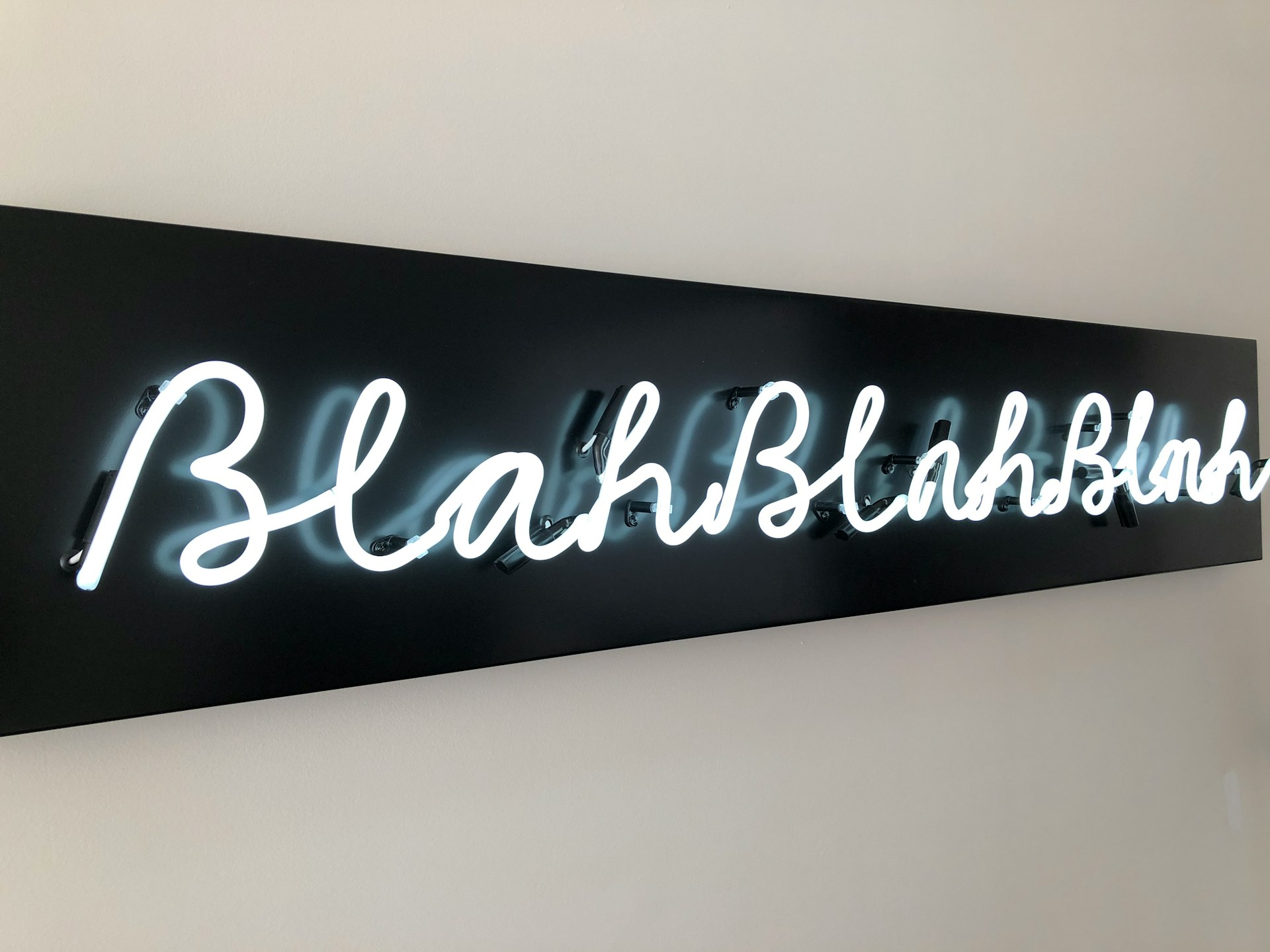 The phrase 'blah blah blah' on a neon sign.  Photo by Nick Fewings on Unsplash.