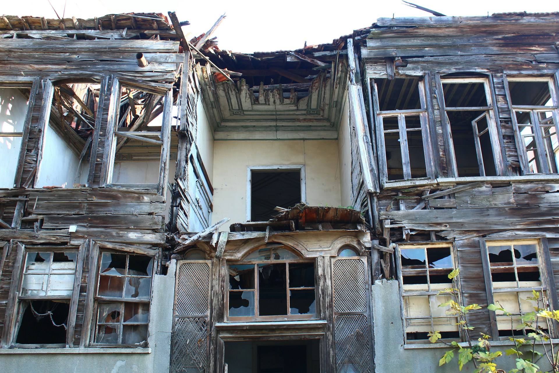A run-down, abandoned house with broken windows.  Photo by Seval Torun on Unsplash.